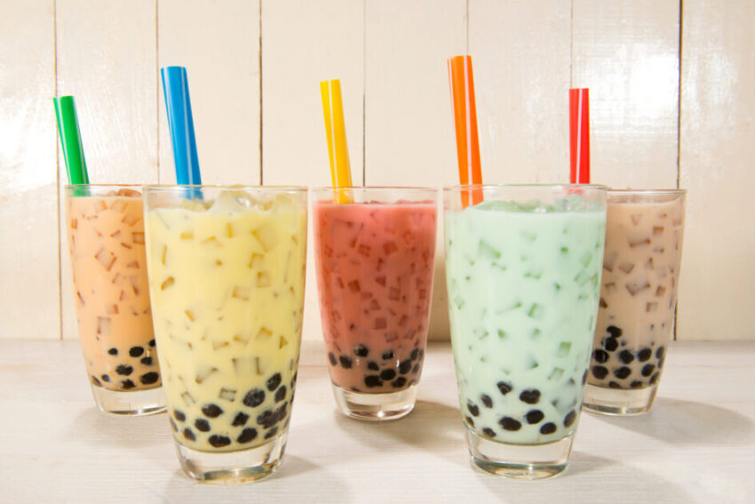 Different color boba tea in multiple glasses with different colored straws