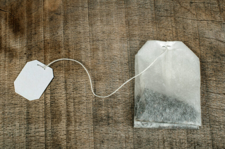 Tea bag with white label on wood plank