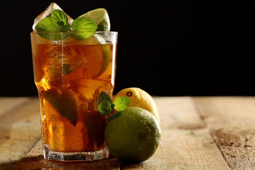 Fresh cold tea with lime, mint and lemon in a glass