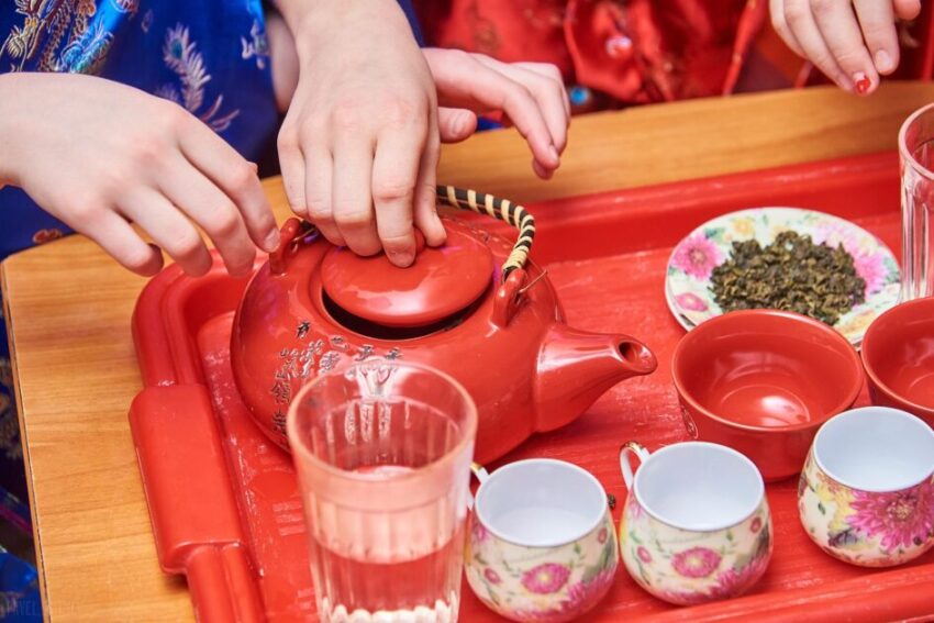 Japanese tea set on red tray on top of wood table
