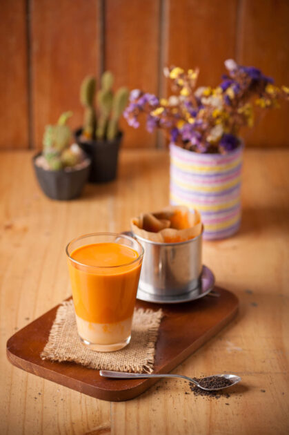 Dripped Thai tea by Vietnamese style with fresh milk in vintage glass on wood table in cafe