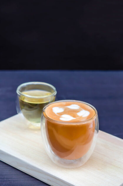 Glass hot Thai tea cup with white foam surface and hot tea