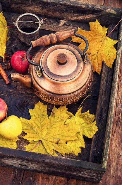 Copper teapot in the background autumn maple leaves
