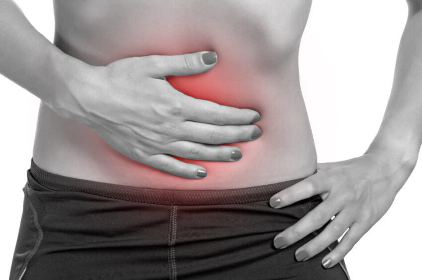 Woman suffering from stomach pain, isolated in white