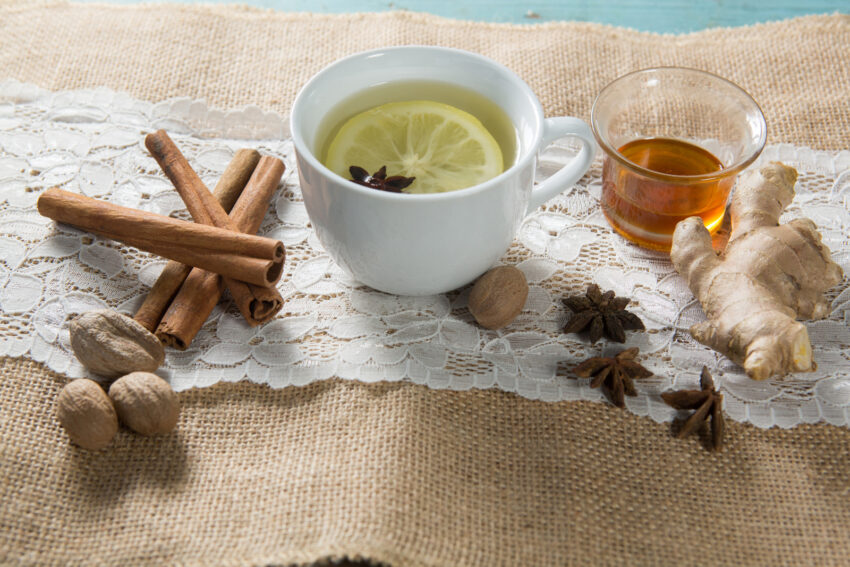 Ginger tea with honey and cinnamons on burlap over table
