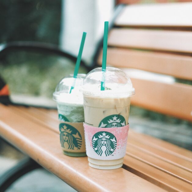 Two Starbucks cups on the bench