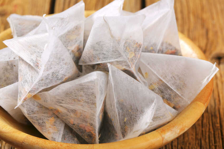 Pyramid-shaped jasmine tea bags in wooden bowl