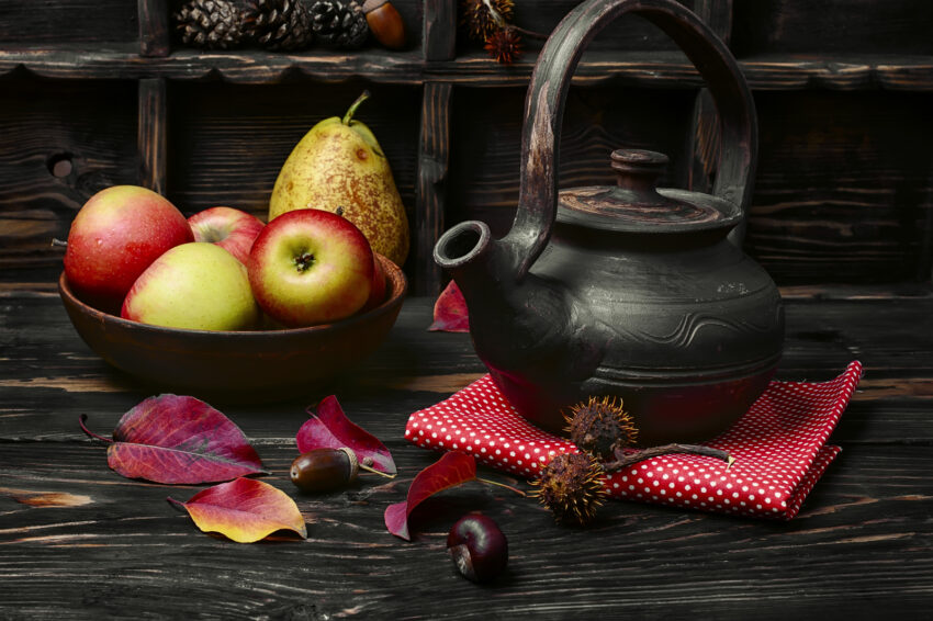 Clay kettle with tea and the autumn harvest autumn apples