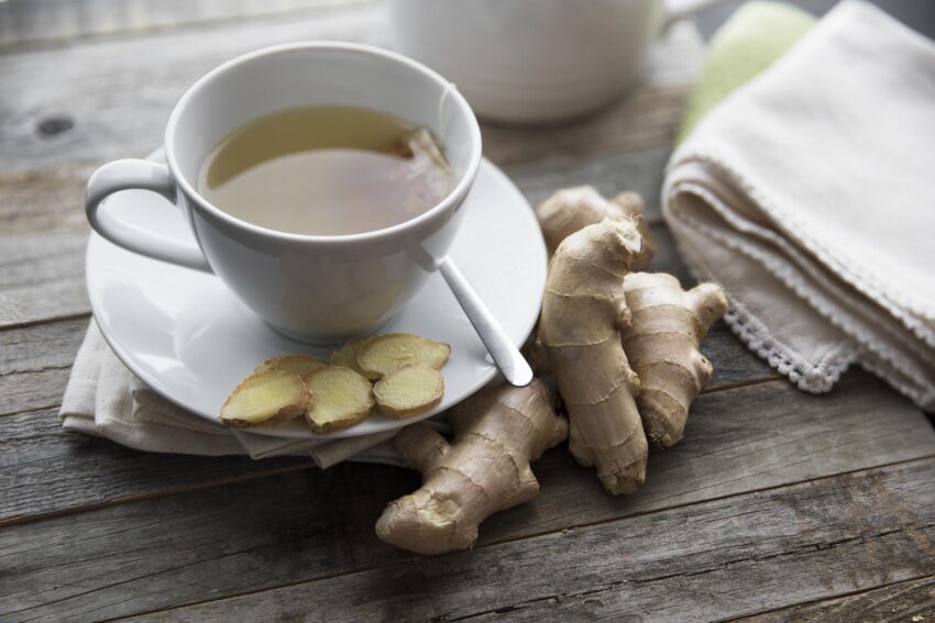 Ginger tea with ginger roots and slices on table