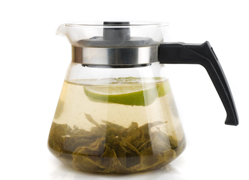 Kettle with green tea isolated on a white background